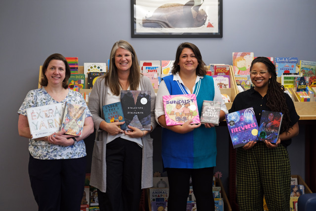 IMC faculty and staff holding children's books